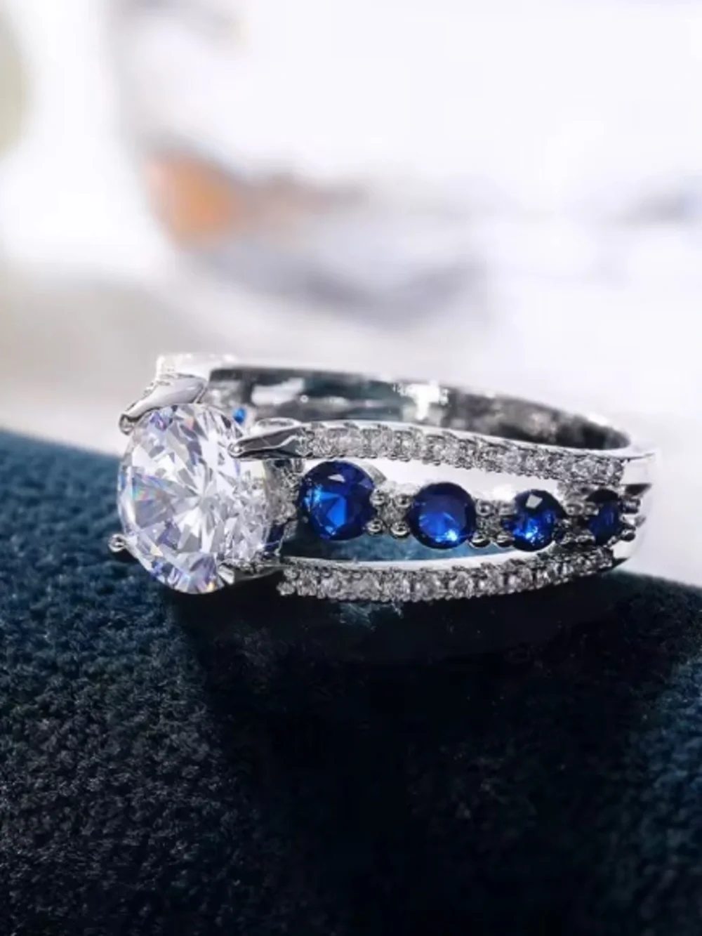 Silver Ring with Deep Blue Stones and Clear Center Gem.